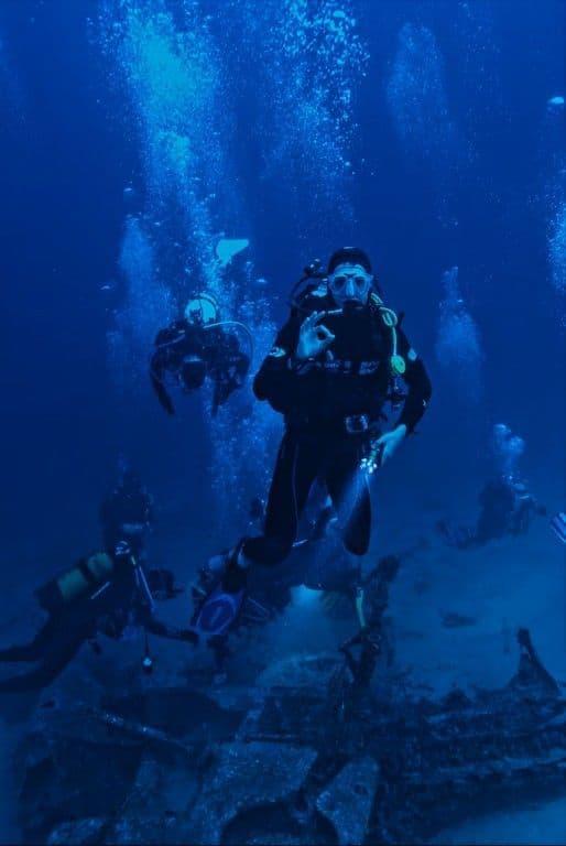 A line of student divers descending into the blue