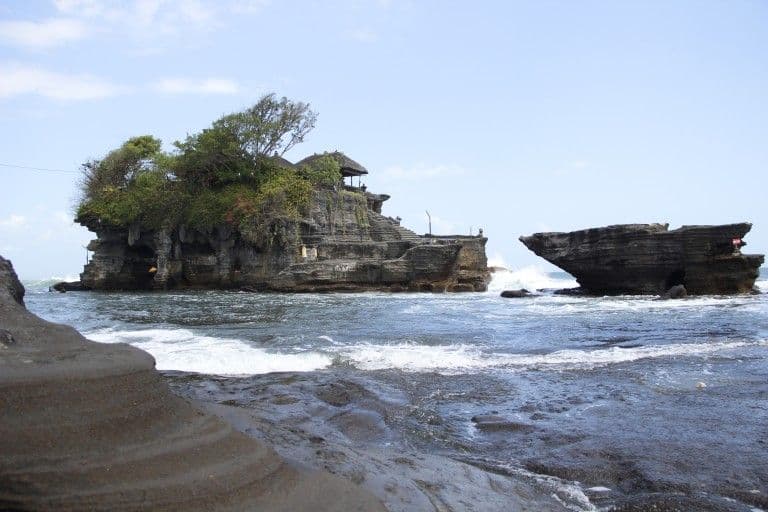 A rock island standing off the shore at high tide